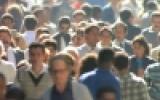 Crowded street with many people walking closely together.